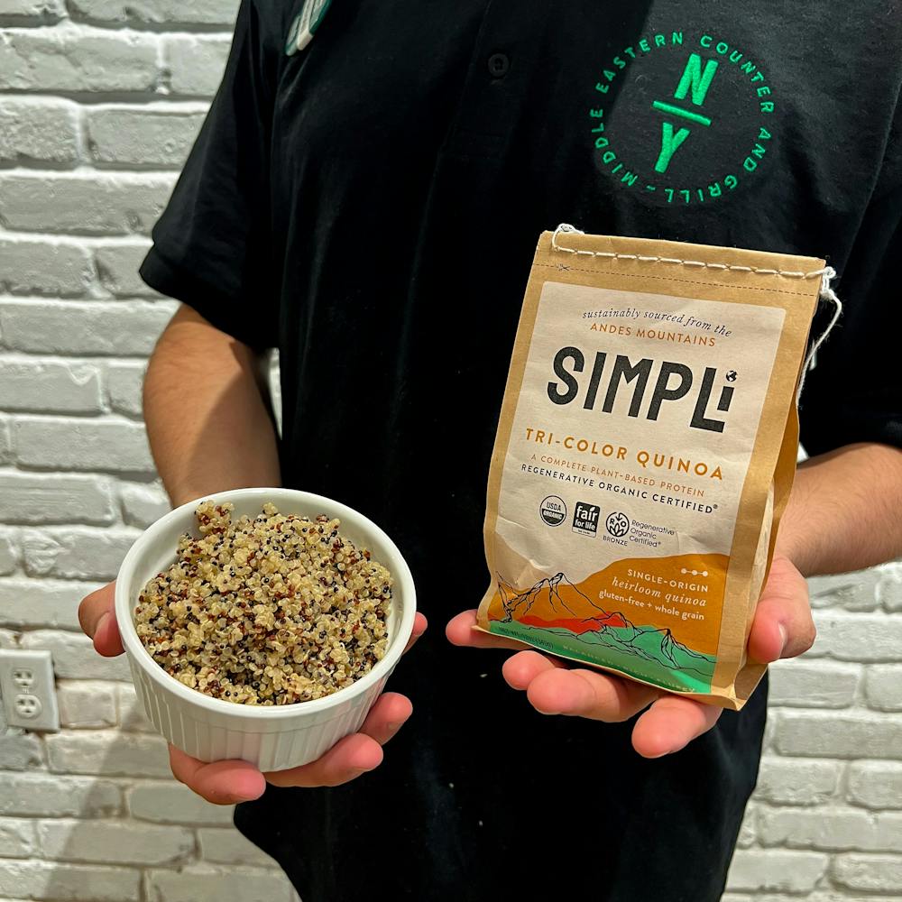 Bowl  of quinoa is held by NAYA team member. Naya now offers quinoa as a base option. Get all your essential amino acids eating quinoa bowls at a Naya near you. Find us near you in NYC, NJ, CT, PA